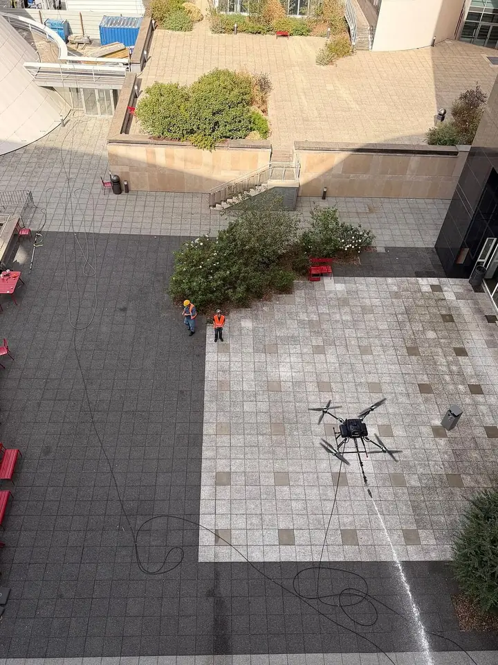 Tethered drone seen from above in a closed courtyard