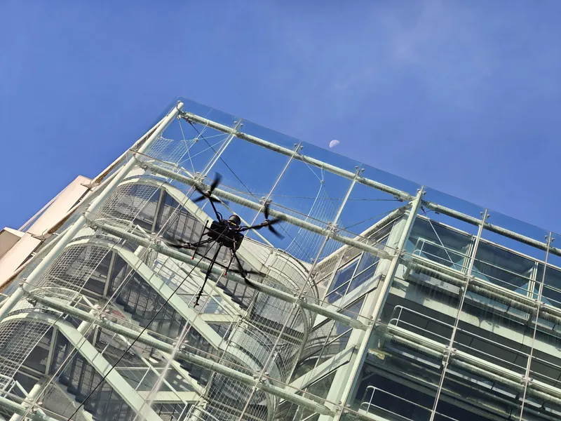 Drone flying in front of the glass stair tower